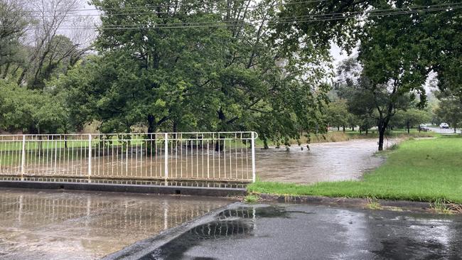 Mittagong Creek spilling over the popular Cherry Tree walk and threatening to flood Rose St. Picture: Adelaide Lang