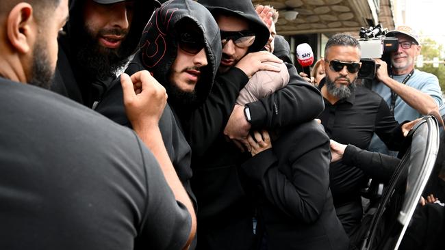 Sarah Abu Lebdeh (centre) is shielded by supporters as she departs the Downing Centre Local Court, Sydney. Picture: AAP