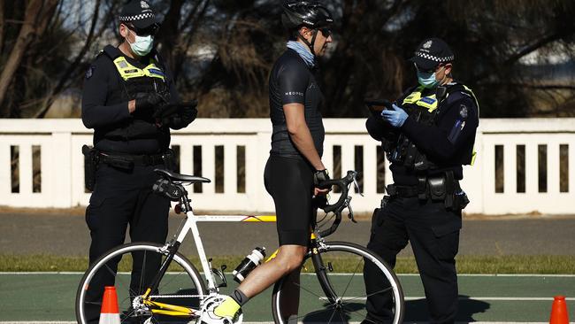 Police check a cyclist’s licence in St Kilda on Sunday. Picture: NCA NewsWire / Daniel Pockett