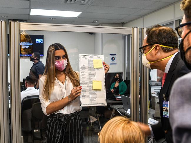 Electoral workers inspect a ballot during the vote-by-mail ballot scanning process at the Miami-Dade County Election Department in Miami, Florida. Picture: AFP