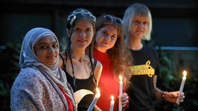 STAND AS ONE: Asraar Ismail, Rosie Williams, Lana Misick and Nina Ashfield-Crook hold a candle for the refugees on Manus and Nauru. Picture: Warren Lynam