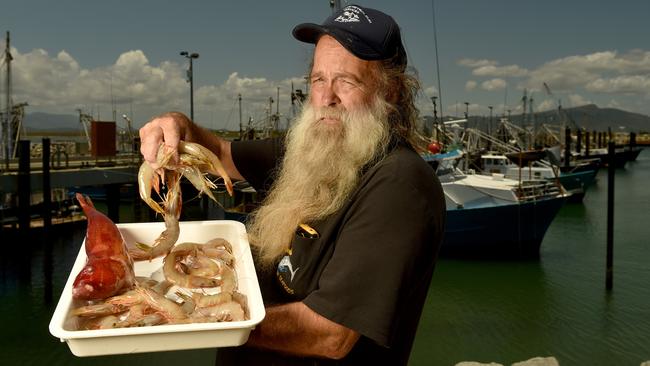 Lounds Seafood owner Col Lound with a coral trout and banana prawns with part of Townsville's fishing fleet. Picture: Evan Morgan