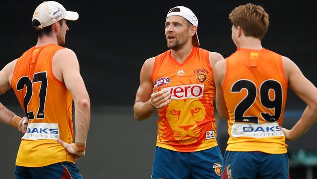 Luke Hodge chats with Lions teammates Darcy Gradiner and Alex Witherden. Picture: Getty Images