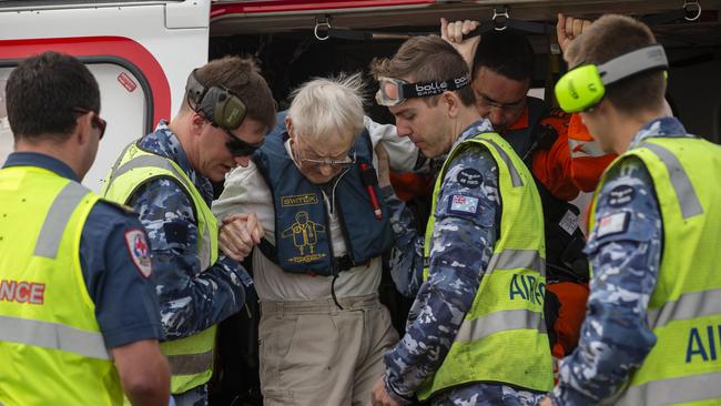 RAAF airmen, Victorian paramedics and CHC search and rescue helicopter crew provide assistance at RAAF Base East Sale for an elderly evacuee during Operation Bushfire Assist.