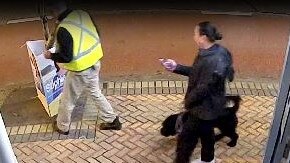 A still from CCTV footage showing a woman, walking her dog, speaking with a man placing a poster for independent candidate Sophie Scamps outside the electorate of sitting Liberal MP Jason Falinski early on Wednesday. Picture: Supplied