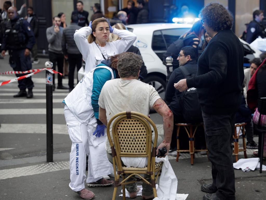 An injured man is treated by emergency workers after the explosion of a bakery. Picture: AFP