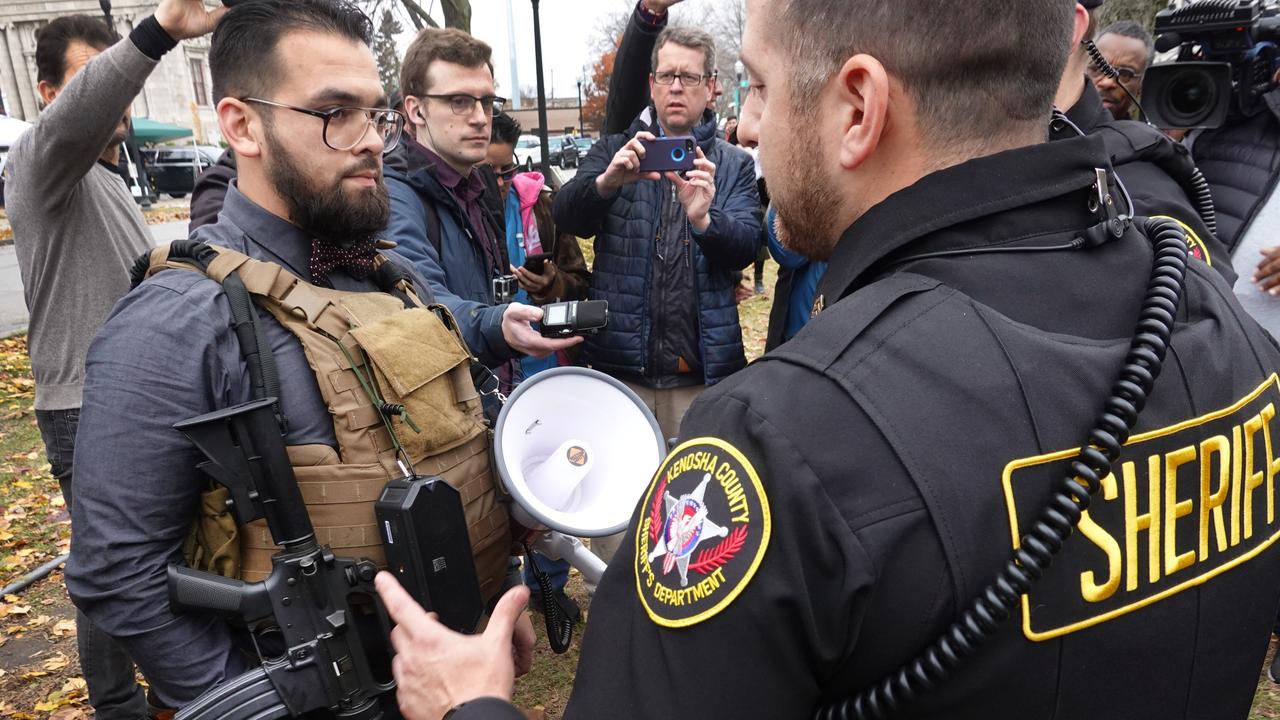 Police question a demonstrator armed with an AR-15 style weapon outside of the Kenosha County Courthouse. Picture: Scott Olson/Getty Images/AFP