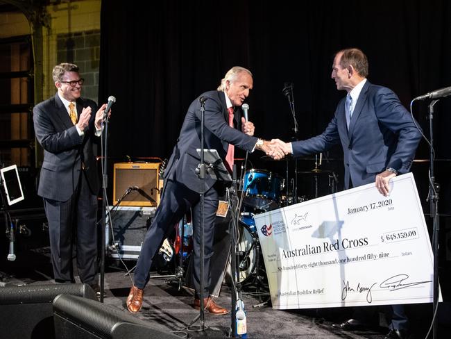 Greg Norman hands Tony Abbott a cheque for bushfire relief in Australia. Picture: Nick Klein