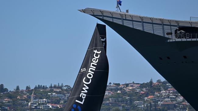 Christian Beck's LawConnect sails past an Australian naval ship. Picture: Saeed Khan/AFP.