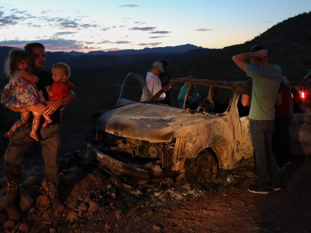 Members of the Lebaron family look at the burned car where part of the nine murdered members of the family were killed and burned during an ambush in Bavispe, Sonora mountains, Mexico, on November 5, 2019. Picture: Herika Martinez/AFP