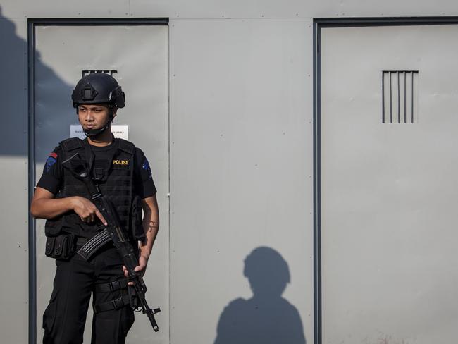 A Indonesian policeman stands guard at Wijayapura port, the entrance gate to Nusakambangan prison. Picture: Ulet Ifansasti