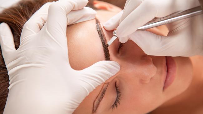 A young woman is receiving eyebrow treatment. Picture: iStock.