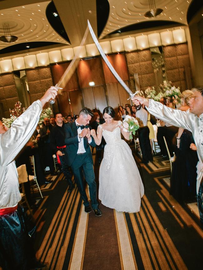 Newlyweds Elia and Hatem are saluted under a traditional sabre arch.