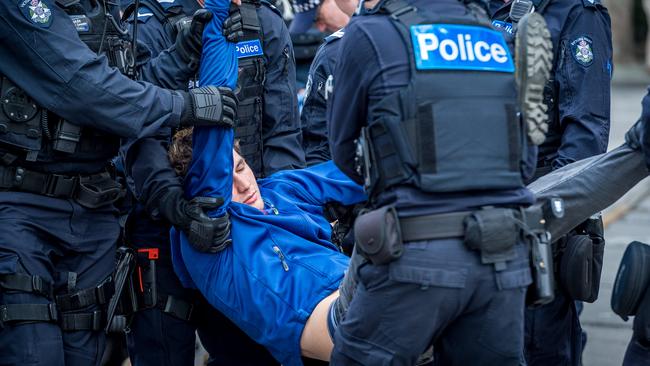 Extinction Rebellion protesters blockade the corner of Spring and Collins Streets before facing arrest. Picture: Jake Nowakowski