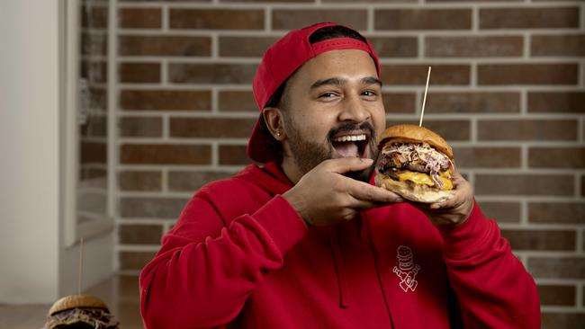 Co-owner of Barry’s Burgers, Rami Paudel with a Staunch Burger, which usually has rocket but now has coleslaw in it. Picture: NCA NewsWire/Naomi Jellicoe