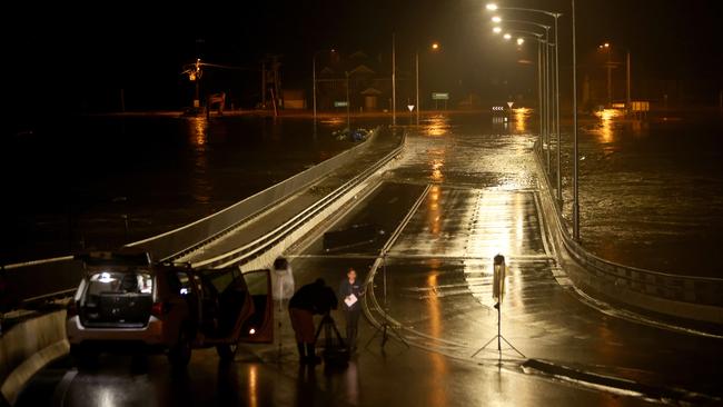 The rising Hawkesbury River flows over the New Windsor Bridge in Windsor, northwest Sydney, at 9.30pm on Sunday. Picture: Damian Shaw