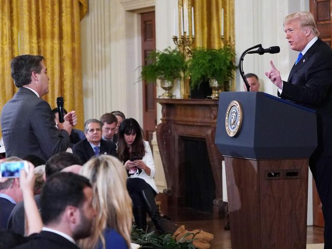 TOPSHOT - US President Donald Trump (R) gets into a heated exchange with CNN chief White House correspondent Jim Acosta (C) as NBC correspondent Peter Alexander (L) looks on during a post-election press conference in the East Room of the White House in Washington, DC on November 7, 2018. (Photo by MANDEL NGAN / AFP)