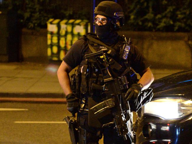 An armed police officer on the scene. Picture: AFP PHOTO / CHRIS J RATCLIFFE