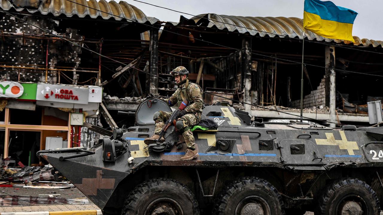 An Ukranian soldier patrols in an armoured vehicle a street in Bucha. Picture: Ronaldo Schemidt/AFP