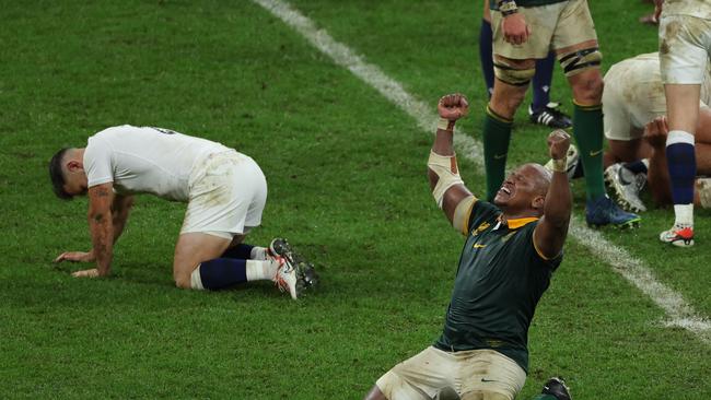 South Africa's hooker Bongi Mbonambi (R) raises his arms and sinks to his knees as he celebrates South Africa's victory at the end of the France 2023 Rugby World Cup semi-final match between England and South Africa at the Stade de France in Saint-Denis, on the outskirts of Paris, on October 21, 2023. (Photo by Thomas SAMSON / AFP)