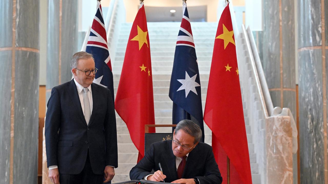 Chinese Premier Li Qiang signs the visitor book as Australia's Prime Minister Anthony Albanese looks on at Australian Parliament House on June 17, 2024 in Canberra. Picture: Getty