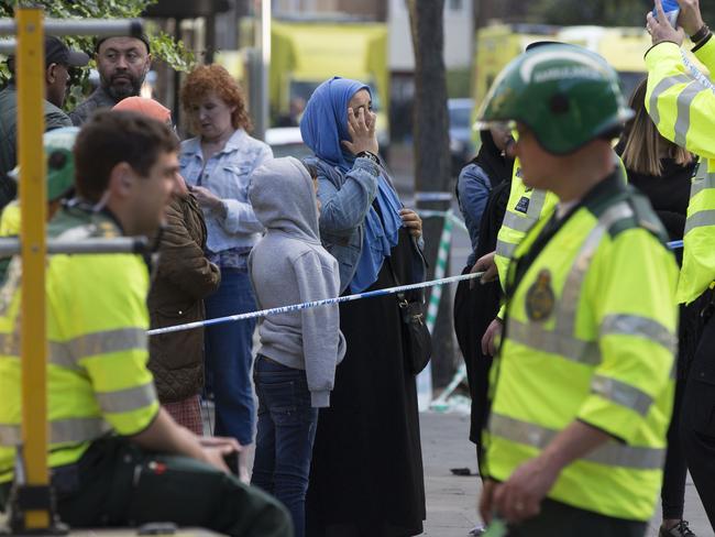 Emergency services pictured with residents near the Grenfell Tower. Picture: AP