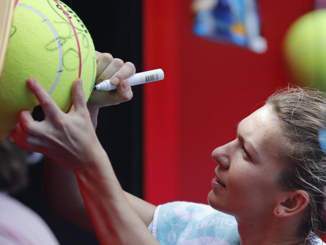 The great escape: Simona Halep signs autographs following her marathon match. Picture: AP