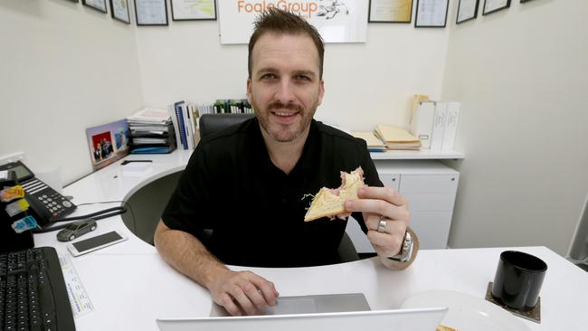 Mortgage broker and financial adviser Nick Foale has lunch at his desk. Picture: Kelly Barnes