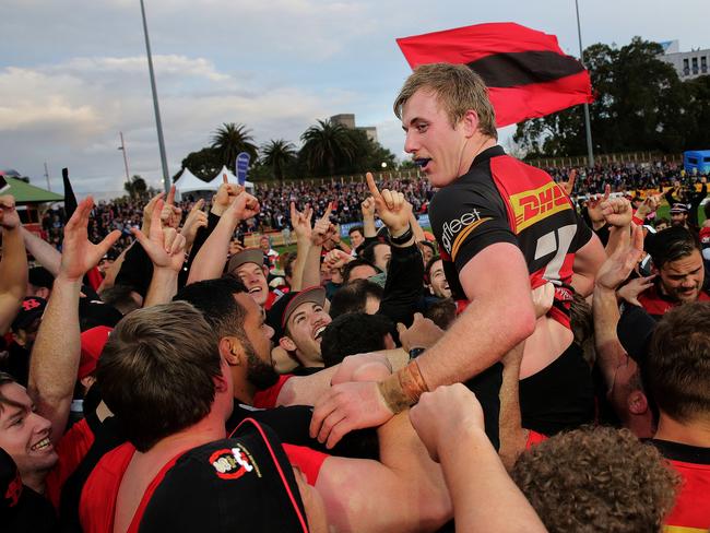 Norths captain Will Miller is hoisted above the crowd after leading the Shoremen to their first Shute Shield title in 41 years. Picture: Troy Snook