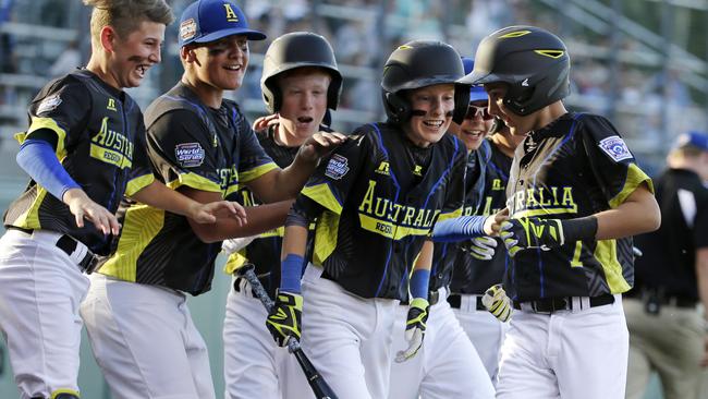 Australia's Stephen Courtney, right, celebrates with teammates after hitting a solo home run off Curacao. Picture: AP