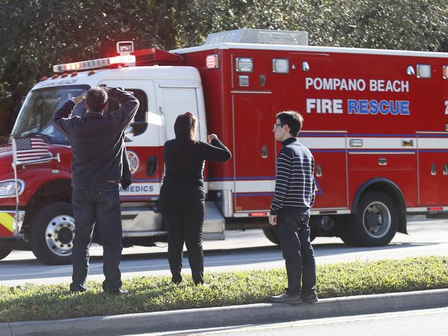 Anxious family members watch a rescue vehicle pass by after the shooting at Marjory Stoneman Douglas High School. Picture: AP Photo/Wilfredo Lee