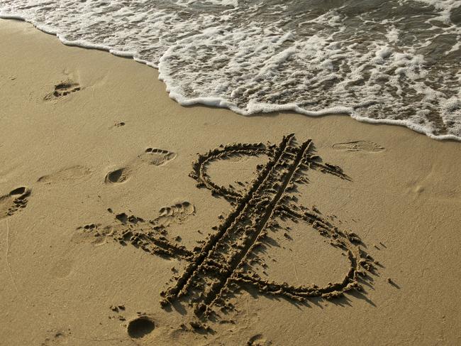 dollar sign drawn on sandy beach.