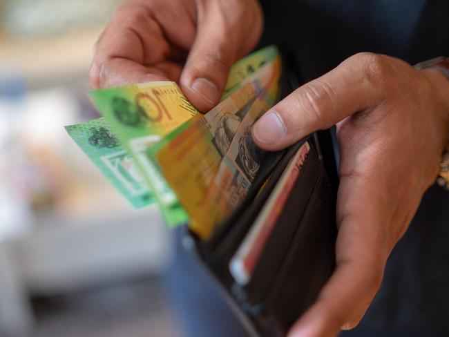 a male taking money out of a wallet, Australian cash generic spending