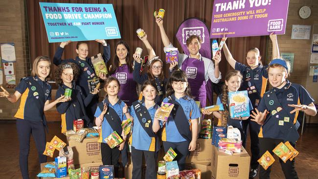 The Coburg Girl Guides celebrate their donation with Alexa Viani and Daniel Parson from Foodbank. Picture: Ellen Smith