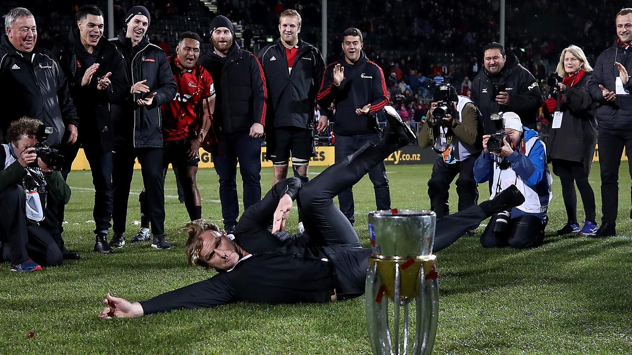 Crusaders coach Scott Robertson breakdances with the Super Rugby trophy.