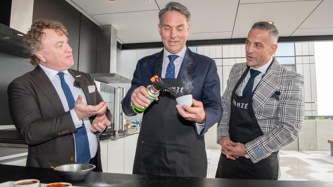 Corio MP Richard Marles practises his creme brulee skills with chef Adrian Richardson (left) and developer Paul Franze at the official opening of Geelong Quarter. Picture: Brad Fleet