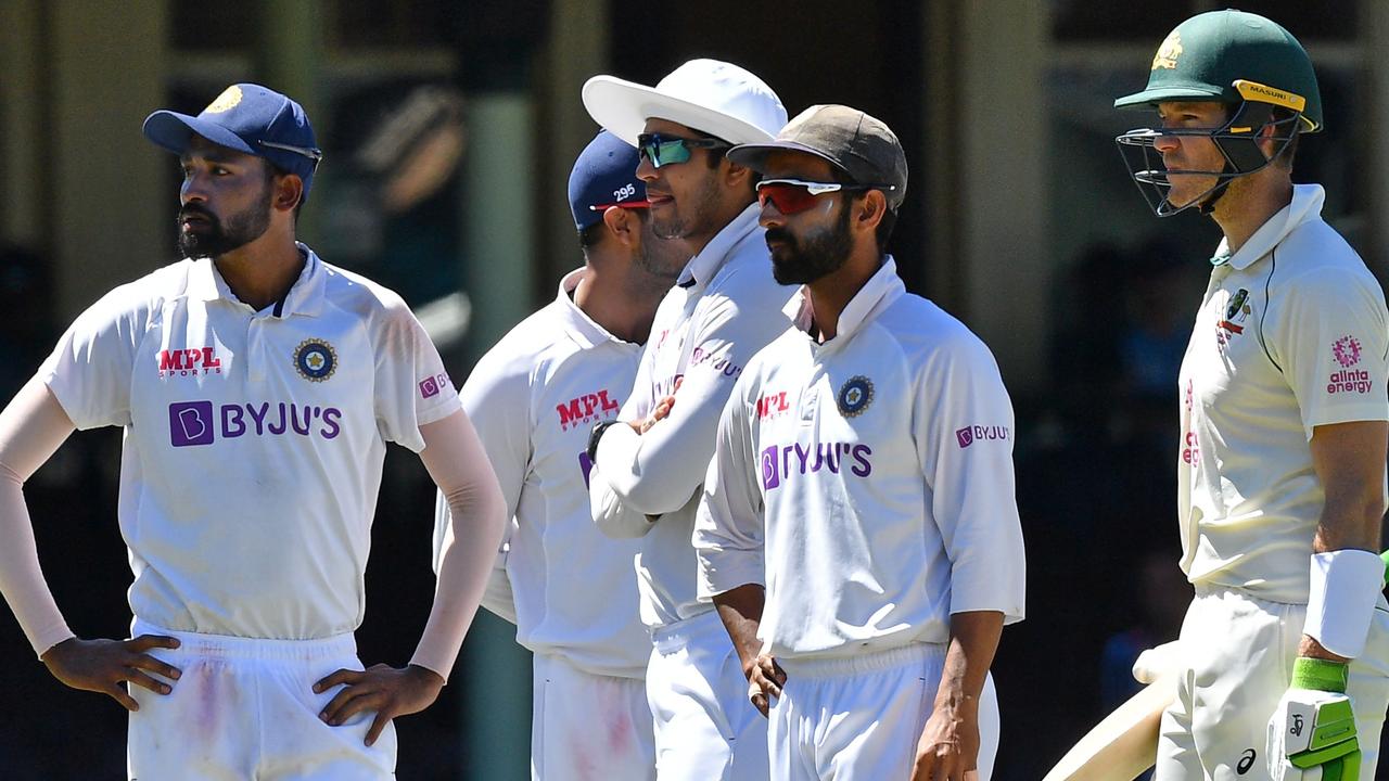 Indian players along with Australia's captain Tim Paine (R) stand as the game was halted after allegedly some remarks were made by the spectators on the fourth day of the third Test.