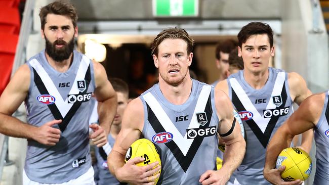 Justin Westhoff runs out with captain Tom Jonas and young gun Connor Rozee. (Photo by Jono Searle/AFL Photos/via Getty Images )