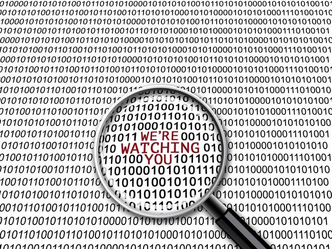 A magnifying glass on binary codes with the words "We're watching you" in focus. istock