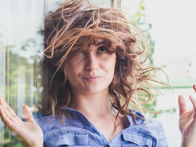 woman with messy hair because of the wind, problem with hairstyle concept; windy weather, wind-blown hair generic