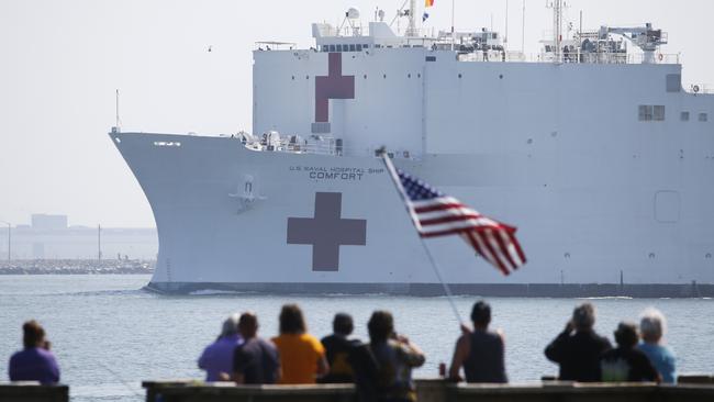 Local residents watch as the USNS Comfort departs Hampton Roads en route to New York to help in the response to the coronavirus outbreak.