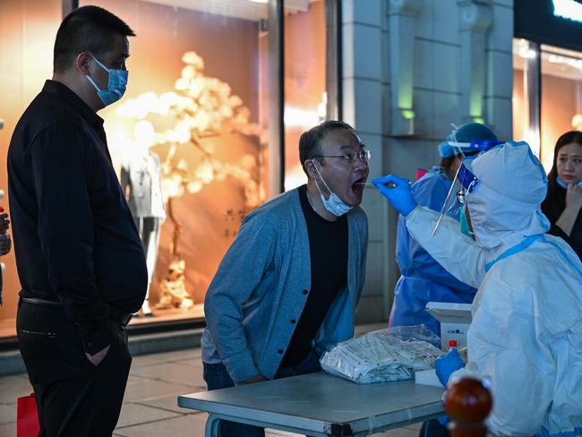 A health worker takes a swab sample from a man to test for the Covid-19 coronavirus in the Huangpu district in Shanghai. Picture: AFP