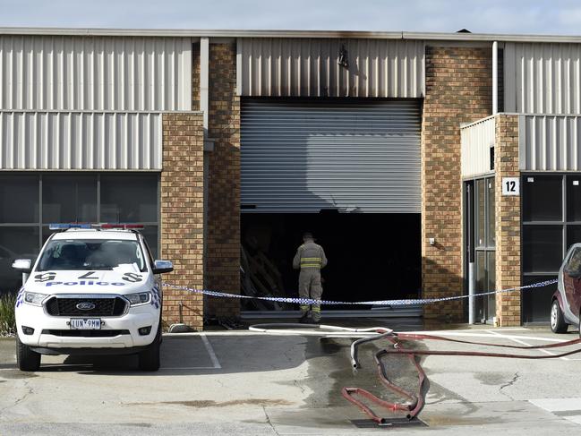 Fire crews and police mop up after the factory blaze. Picture: Andrew Henshaw