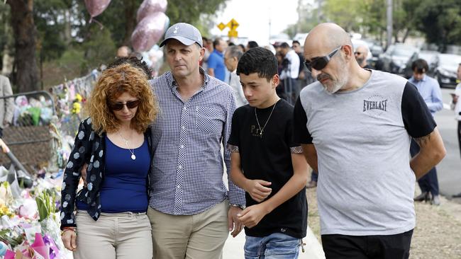 Veronique’s mother Bridget Sakr with partner Craig Mackenzie, brother Michael and father Bob Sakr look at the tributes left by people at the Oatlands crash site.