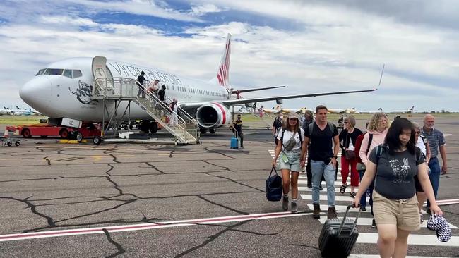 Passengers and tourists arrive on the Alice Springs tarmac in January. The NT government has said 2022 was a record year for tourism in the territory, but other figures show a massive decrease on pre-pandemic levels.