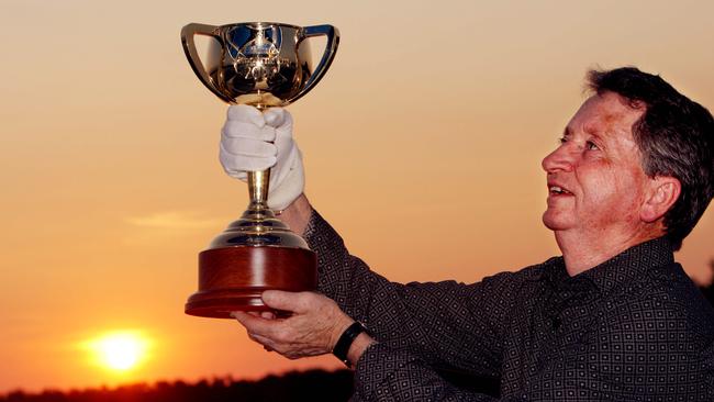 Dual Melbourne Cup winning jockey John Letts holds the cup aloft in the Kakadu National Park during the Melbourne Cup Tour.