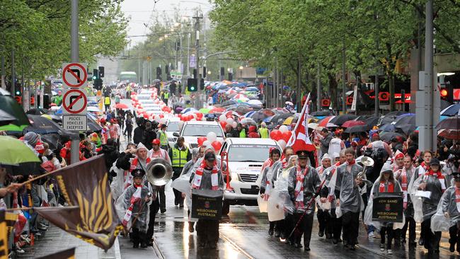 Supporters for Hawthorn and Sydney on the wet streets of Melbourne for the 2012 AFL Grand Final Parade. Picture: HWT Library.