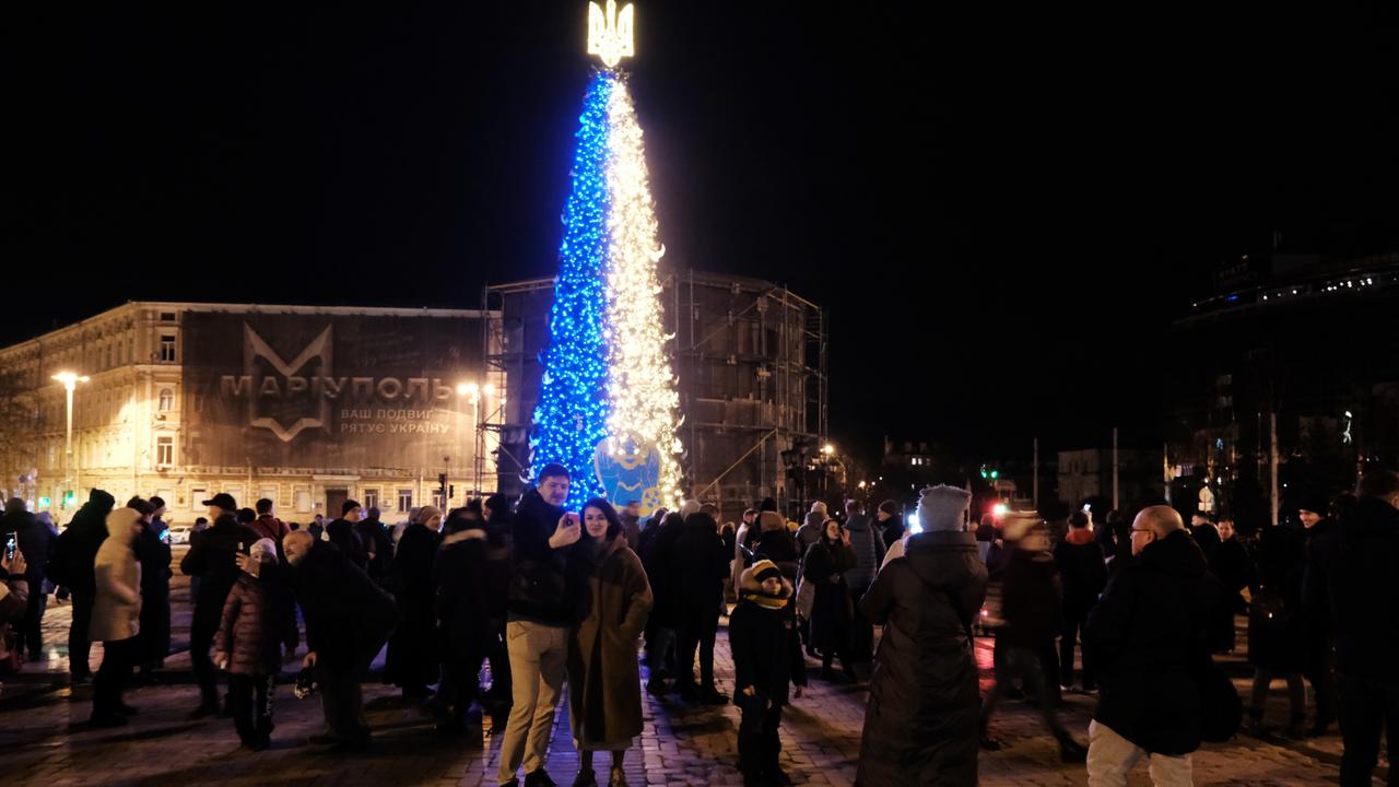 People gather near a Christmas tree decorated in the colours of the Ukrainian flag in a Kyiv square on New Year's Eve. Picture: Spencer Platt/Getty Images