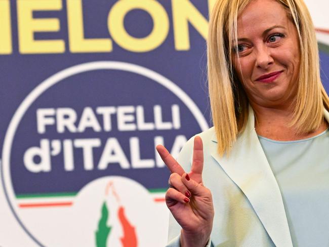 TOPSHOT - Leader of Italian far-right party "Fratelli d'Italia" (Brothers of Italy), Giorgia Meloni flashes a victory sign as she acknowledges the audience after she delivered an address at her party's campaign headquarters overnight on September 26, 2022 in Rome, after the country voted in a legislative election. - Far-right leader Giorgia Meloni won big in Italian elections on September 25, the first projections suggested, putting her eurosceptic populists on course to take power at the heart of Europe. (Photo by Andreas SOLARO / AFP)