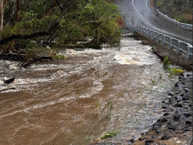 Floodwaters rage near a new bridge just outside between Nambour and Yandina after heavy rain on the Sunshine Coast.